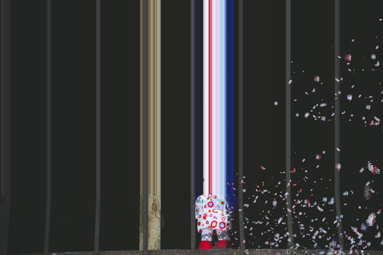 A doll behind iron bars, its image stretched into coloured streaks and scattering fragments