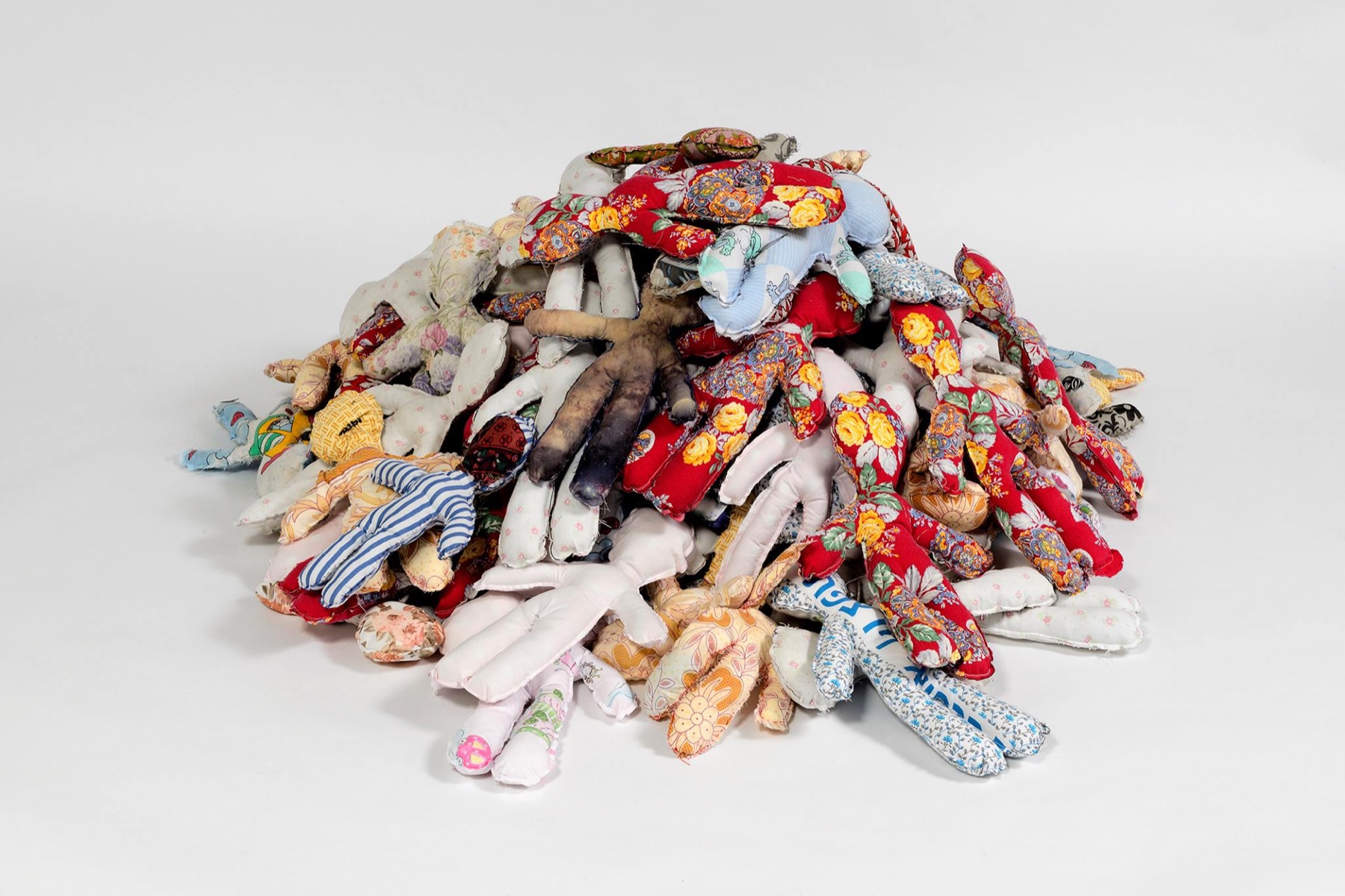 A large heap of dolls sewn from floral and striped household fabrics